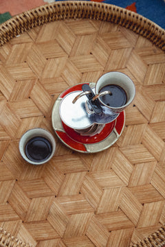Overhead view of the Turbo Moka Duetto on a woven tray with two cups of freshly brewed coffee
